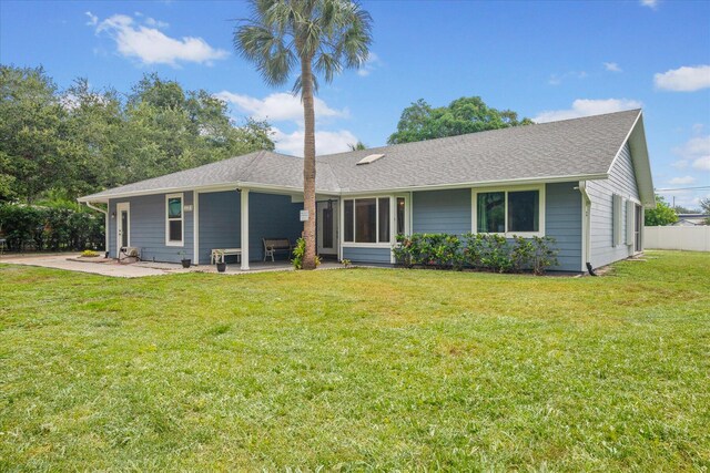 11038 Monet Ln, Palm Beach Gardens, FL 33410 - view of front of home with a patio area, a front lawn, and a shingled roof