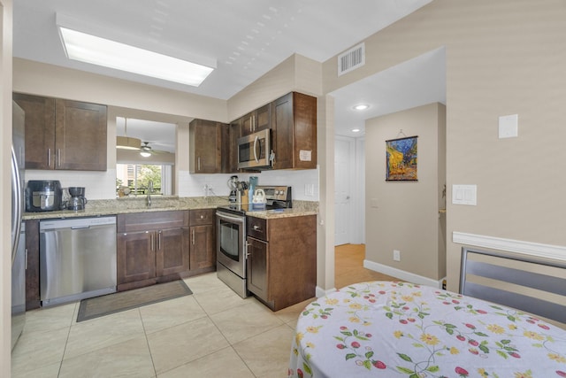 14375 Strathmore Ln Unit 306, Delray Beach, FL 33446 - kitchen featuring stainless steel appliances, decorative backsplash, dark brown cabinetry, light stone counters, and light tile patterned flooring