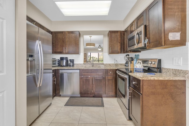 14375 Strathmore Ln Unit 306, Delray Beach, FL 33446 - kitchen featuring appliances with stainless steel finishes, tasteful backsplash, light stone counters, light tile patterned floors, and a ceiling fan