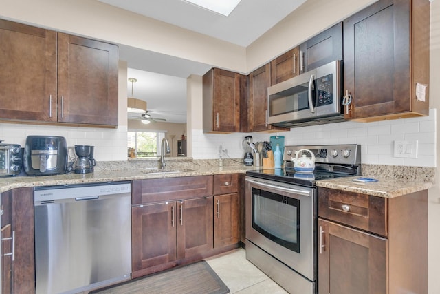 14375 Strathmore Ln Unit 306, Delray Beach, FL 33446 - kitchen with stainless steel appliances, decorative backsplash, a ceiling fan, light stone countertops, and dark brown cabinetry