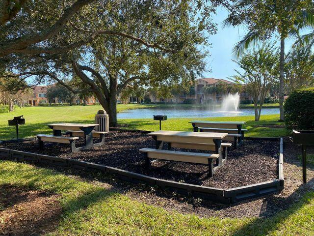 261 SW Palm Dr Unit 205, Port Saint Lucie, FL 34986 - surrounding community with a water view and a lawn