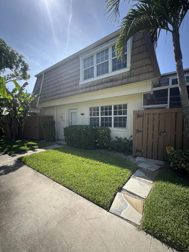4348 Hazel Ave Unit B, Palm Beach Gardens, FL 33410 - view of front facade with a gate, mansard roof, and stucco siding
