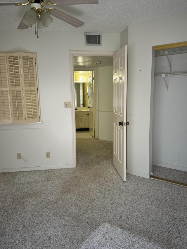 4348 Hazel Ave Unit B, Palm Beach Gardens, FL 33410 - unfurnished bedroom featuring light carpet, a textured ceiling, a closet, a ceiling fan, and baseboards