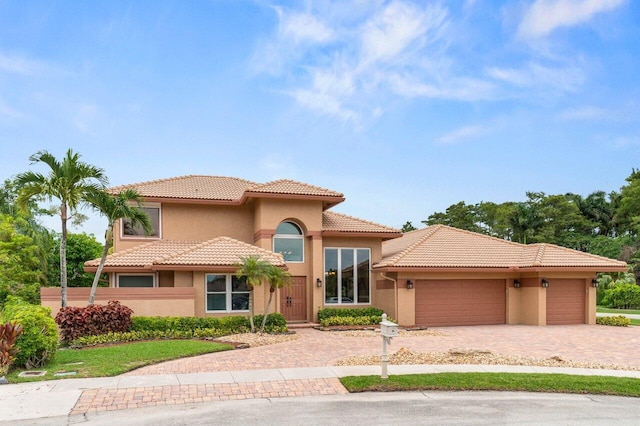 9556 E Lake Dr, Boca Raton, FL 33434 - mediterranean / spanish home with stucco siding, decorative driveway, a garage, and a tile roof