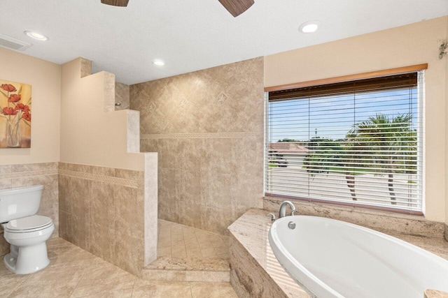 9556 E Lake Dr, Boca Raton, FL 33434 - bathroom with a garden tub, a ceiling fan, walk in shower, tile walls, and tile patterned floors