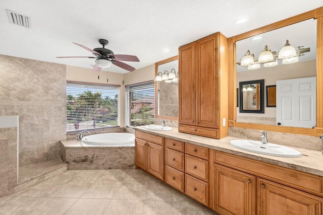 9556 E Lake Dr, Boca Raton, FL 33434 - full bath featuring a garden tub, double vanity, a ceiling fan, tile patterned floors, and a textured ceiling