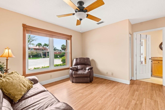 9556 E Lake Dr, Boca Raton, FL 33434 - sitting room with light wood-style floors, a ceiling fan, and a textured ceiling