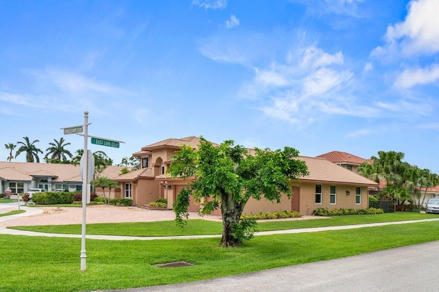 9556 E Lake Dr, Boca Raton, FL 33434 - view of front of home with decorative driveway, a tiled roof, a front lawn, and stucco siding