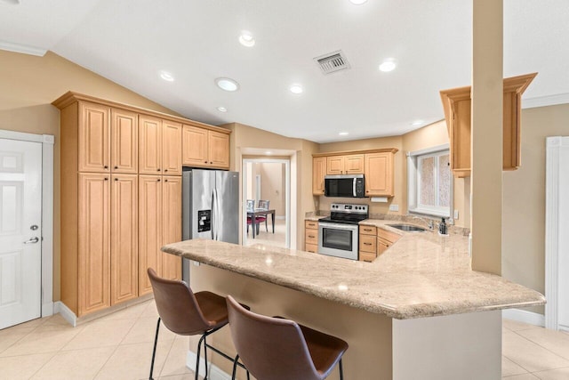 9556 E Lake Dr, Boca Raton, FL 33434 - kitchen with appliances with stainless steel finishes, a peninsula, light brown cabinets, light tile patterned floors, and vaulted ceiling