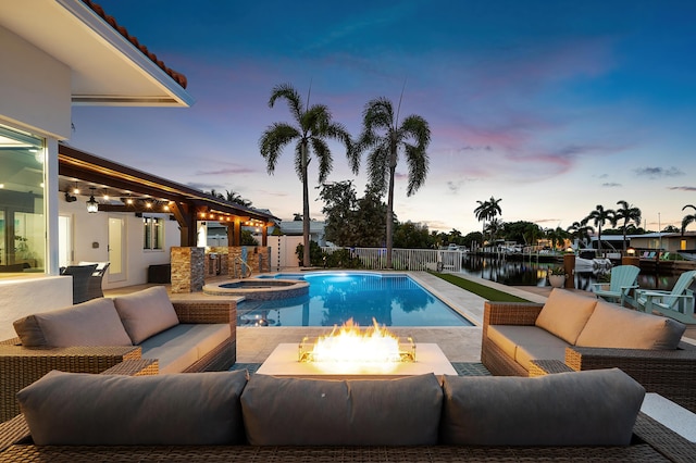 400 SE 5th Ter, Pompano Beach, FL 33060 - view of pool featuring an outdoor living space with a fire pit, a patio, a fenced backyard, a pool with connected hot tub, and a water view
