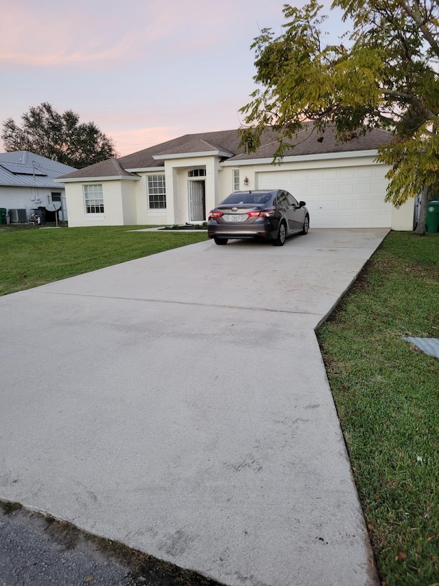 1701 SW Victor Ln SW, Port Saint Lucie, FL 34984 - ranch-style home featuring concrete driveway, a yard, stucco siding, and an attached garage