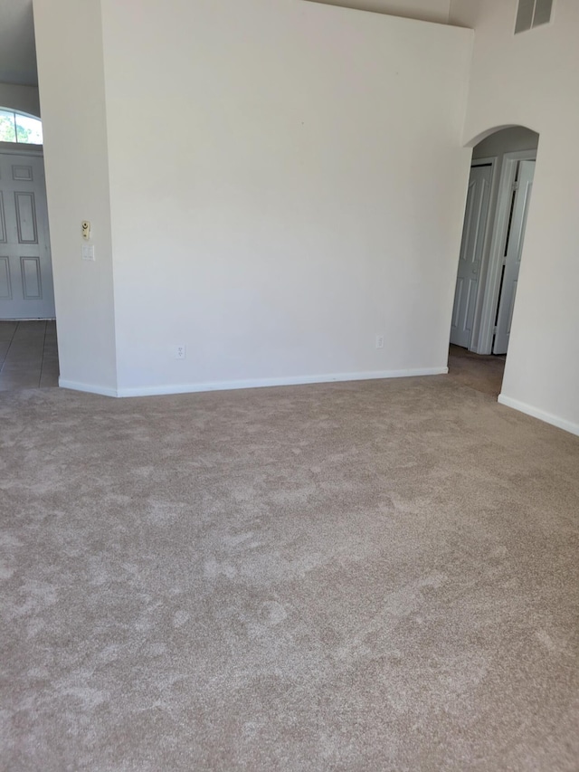 1701 SW Victor Ln SW, Port Saint Lucie, FL 34984 - spare room with carpet flooring, arched walkways, and a towering ceiling
