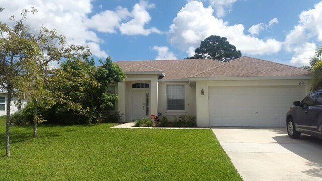 1701 SW Victor Ln SW, Port Saint Lucie, FL 34984 - single story home featuring stucco siding, driveway, a front lawn, a garage, and roof with shingles