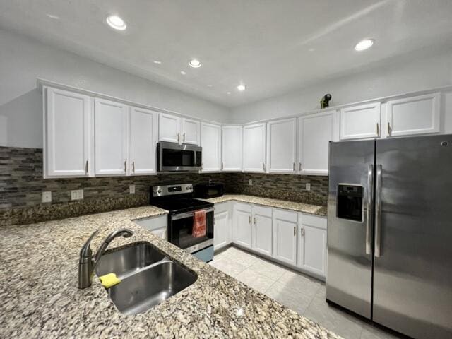 3841 E Aspen Leaf Dr, Boynton Beach, FL 33436 - kitchen with stainless steel appliances, a sink, light stone countertops, white cabinetry, and recessed lighting