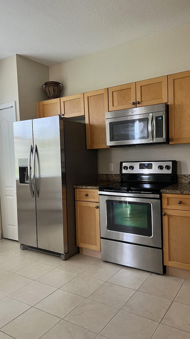 11021 Legacy Ln Unit 302, Palm Beach Gardens, FL 33410 - kitchen with stainless steel appliances, a textured ceiling, and light tile patterned floors