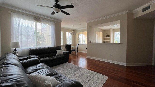 11021 Legacy Ln Unit 302, Palm Beach Gardens, FL 33410 - living room featuring dark wood finished floors, ornamental molding, ceiling fan, and a chandelier