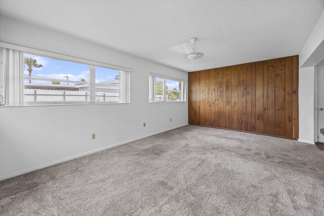 5557 S Shadyside Cir, West Palm Beach, FL 33415 - carpeted spare room featuring wooden walls, a textured ceiling, a ceiling fan, and baseboards