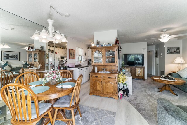 1225 NW 21st St Unit 7-710, Stuart, FL 34994 - dining space with ceiling fan, light wood-type flooring, a textured ceiling, and a chandelier