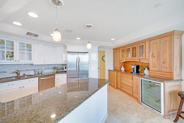 19850 Beach Rd Unit 8D, Jupiter, FL 33469 - kitchen with appliances with stainless steel finishes, wine cooler, a sink, pendant lighting, and glass insert cabinets