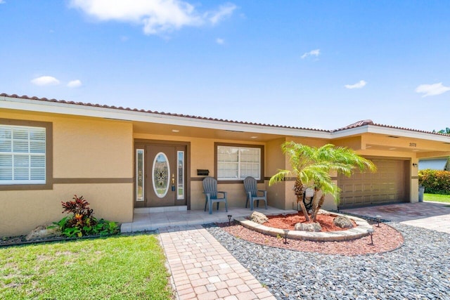 2070 NE 27th St, Lighthouse Point, FL 33064 - view of front of home featuring stucco siding, a garage, and driveway