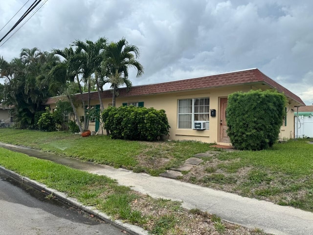 4601 Lake Ave, West Palm Beach, FL 33405 - view of front of home with stucco siding, a front yard, and cooling unit