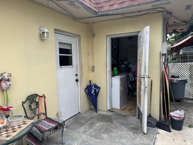 4601 Lake Ave, West Palm Beach, FL 33405 - doorway to property with washer and dryer and stucco siding