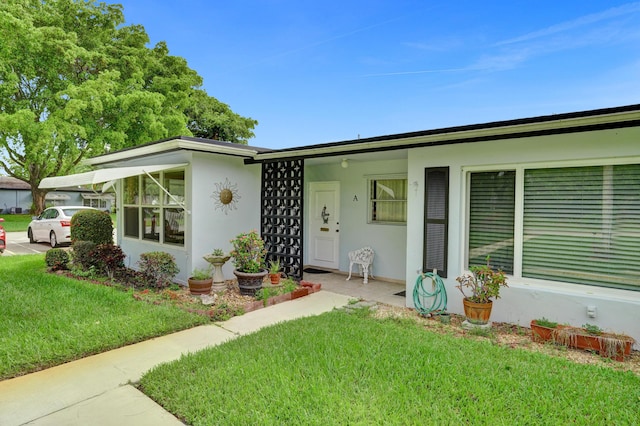 505 High Point Blvd N Unit A, Delray Beach, FL 33445 - mid-century modern home featuring a front lawn and stucco siding