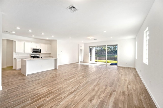 18478 Claybrook St, Jupiter, FL 33458 - unfurnished living room featuring light wood-style floors, recessed lighting, and baseboards