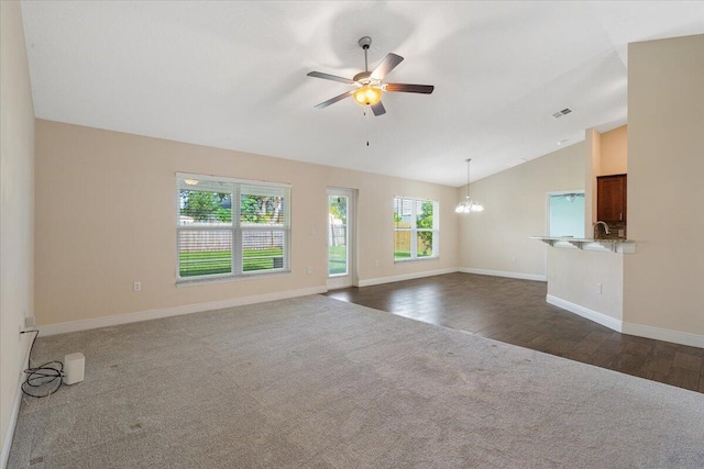 3650 SW Parsons St, Port Saint Lucie, FL 34953 - unfurnished living room with vaulted ceiling, a chandelier, dark colored carpet, ceiling fan, and baseboards