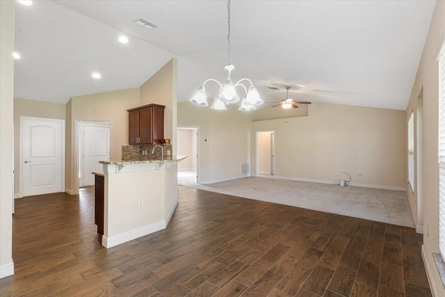 3650 SW Parsons St, Port Saint Lucie, FL 34953 - kitchen featuring vaulted ceiling, a ceiling fan, a breakfast bar, a chandelier, and light stone countertops