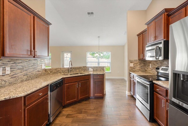 3650 SW Parsons St, Port Saint Lucie, FL 34953 - kitchen featuring appliances with stainless steel finishes, a sink, dark wood finished floors, a peninsula, and a chandelier