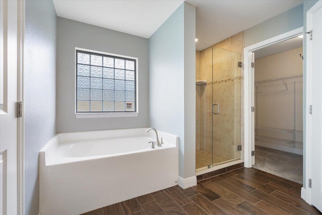 3650 SW Parsons St, Port Saint Lucie, FL 34953 - full bathroom with a garden tub, a shower stall, wood finish floors, and a walk in closet