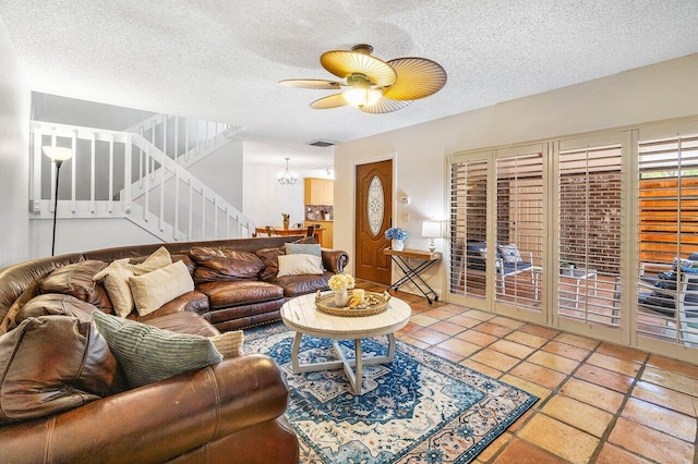 125 1st Ter, Palm Beach Gardens, FL 33418 - living area featuring stairs, a chandelier, a ceiling fan, and a textured ceiling