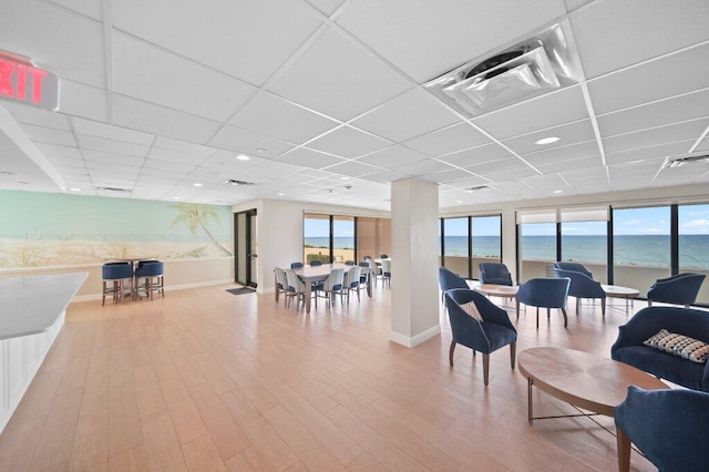 8750 S Ocean Dr Unit 731, Jensen Beach, FL 34957 - living area featuring wood finished floors, a paneled ceiling, a water view, and baseboards