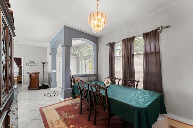 165 SE Osprey Rdg, Port Saint Lucie, FL 34984 - dining area featuring arched walkways, a chandelier, baseboards, and light tile patterned floors