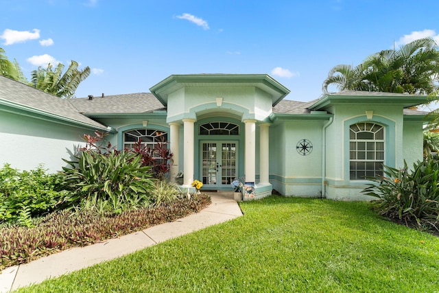 165 SE Osprey Rdg, Port Saint Lucie, FL 34984 - view of exterior entry with french doors, stucco siding, a lawn, and a shingled roof
