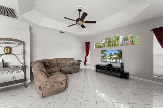 165 SE Osprey Rdg, Port Saint Lucie, FL 34984 - living room featuring a tray ceiling, a ceiling fan, and baseboards