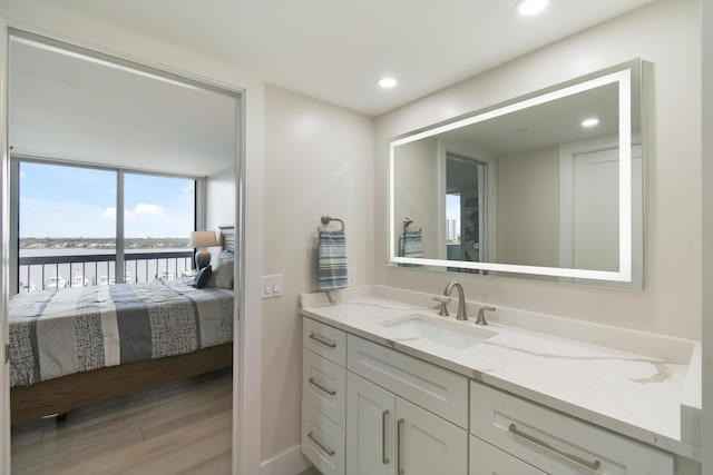 123 Lakeshore Dr Unit 1145, North Palm Beach, FL 33408 - ensuite bathroom with vanity, a water view, wood finished floors, recessed lighting, and baseboards