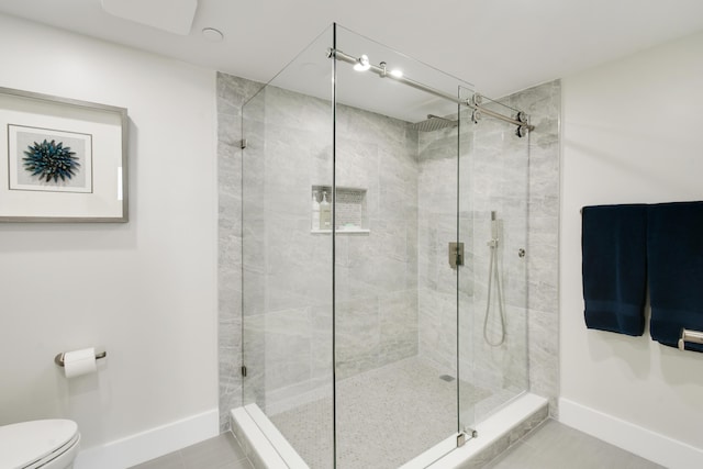 123 Lakeshore Dr Unit 1145, North Palm Beach, FL 33408 - bathroom featuring a stall shower, toilet, baseboards, and tile patterned floors