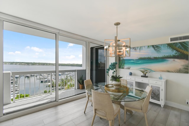 123 Lakeshore Dr Unit 1145, North Palm Beach, FL 33408 - dining room featuring a chandelier, a water view, light wood-style flooring, and expansive windows