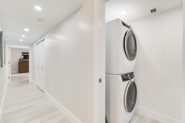 123 Lakeshore Dr Unit 1145, North Palm Beach, FL 33408 - washroom with estacked washer and dryer, recessed lighting, baseboards, and light wood finished floors