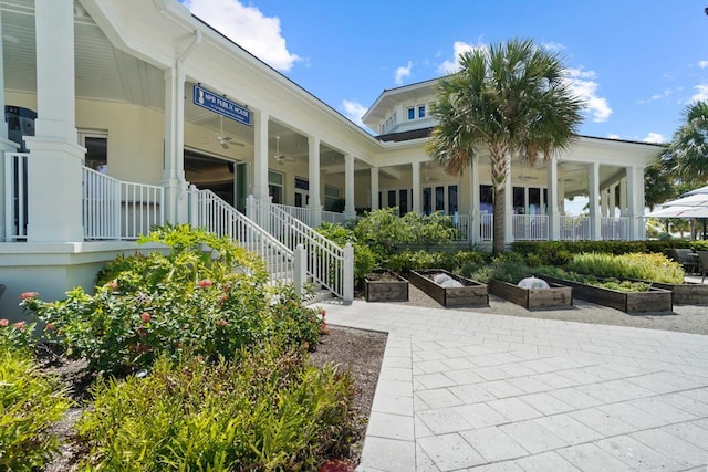 123 Lakeshore Dr Unit 1145, North Palm Beach, FL 33408 - covered porch with a garden, ceiling fan, and stairs