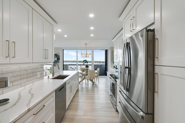 123 Lakeshore Dr Unit 1145, North Palm Beach, FL 33408 - kitchen featuring stainless steel appliances, backsplash, a sink, recessed lighting, and white cabinetry