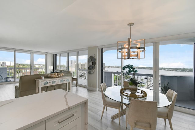 123 Lakeshore Dr Unit 1145, North Palm Beach, FL 33408 - dining area featuring a chandelier, a wall of windows, a water view, and light wood-type flooring