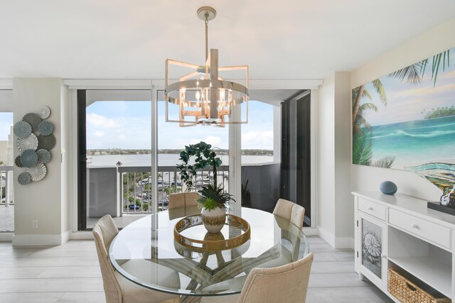 123 Lakeshore Dr Unit 1145, North Palm Beach, FL 33408 - dining space featuring a chandelier, expansive windows, baseboards, and a water view