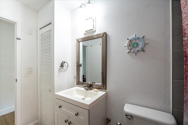 300 SW Prima Vista Blvd, Port Saint Lucie, FL 34983 - bathroom featuring toilet, vanity, a closet, and wood finished floors