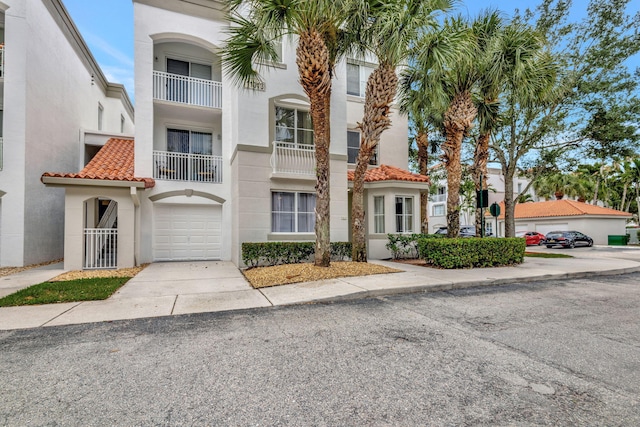 11013 Legacy Ln Unit 103, Palm Beach Gardens, FL 33410 - view of front of house featuring stucco siding, a tile roof, and concrete driveway
