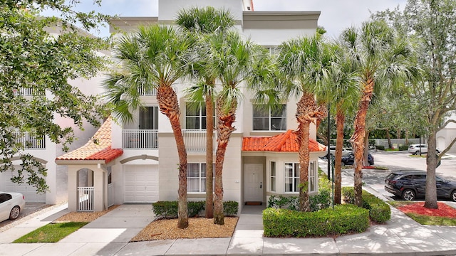 11013 Legacy Ln Unit 103, Palm Beach Gardens, FL 33410 - view of property with stucco siding, a tile roof, and an attached garage