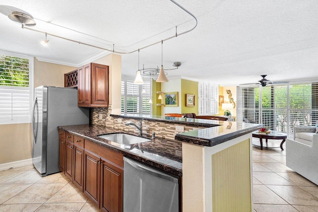 3606 S Ocean Blvd Unit 201, Highland Beach, FL 33487 - kitchen with stainless steel appliances, a sink, a textured ceiling, decorative backsplash, and brown cabinets