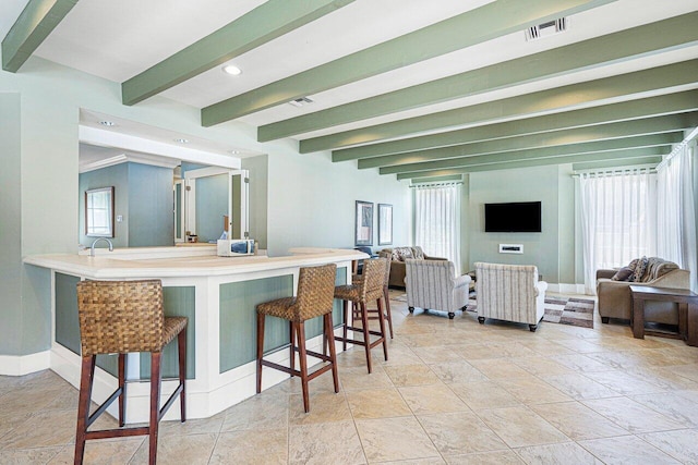 3606 S Ocean Blvd Unit 201, Highland Beach, FL 33487 - kitchen with a kitchen breakfast bar, open floor plan, beam ceiling, stone tile flooring, and baseboards